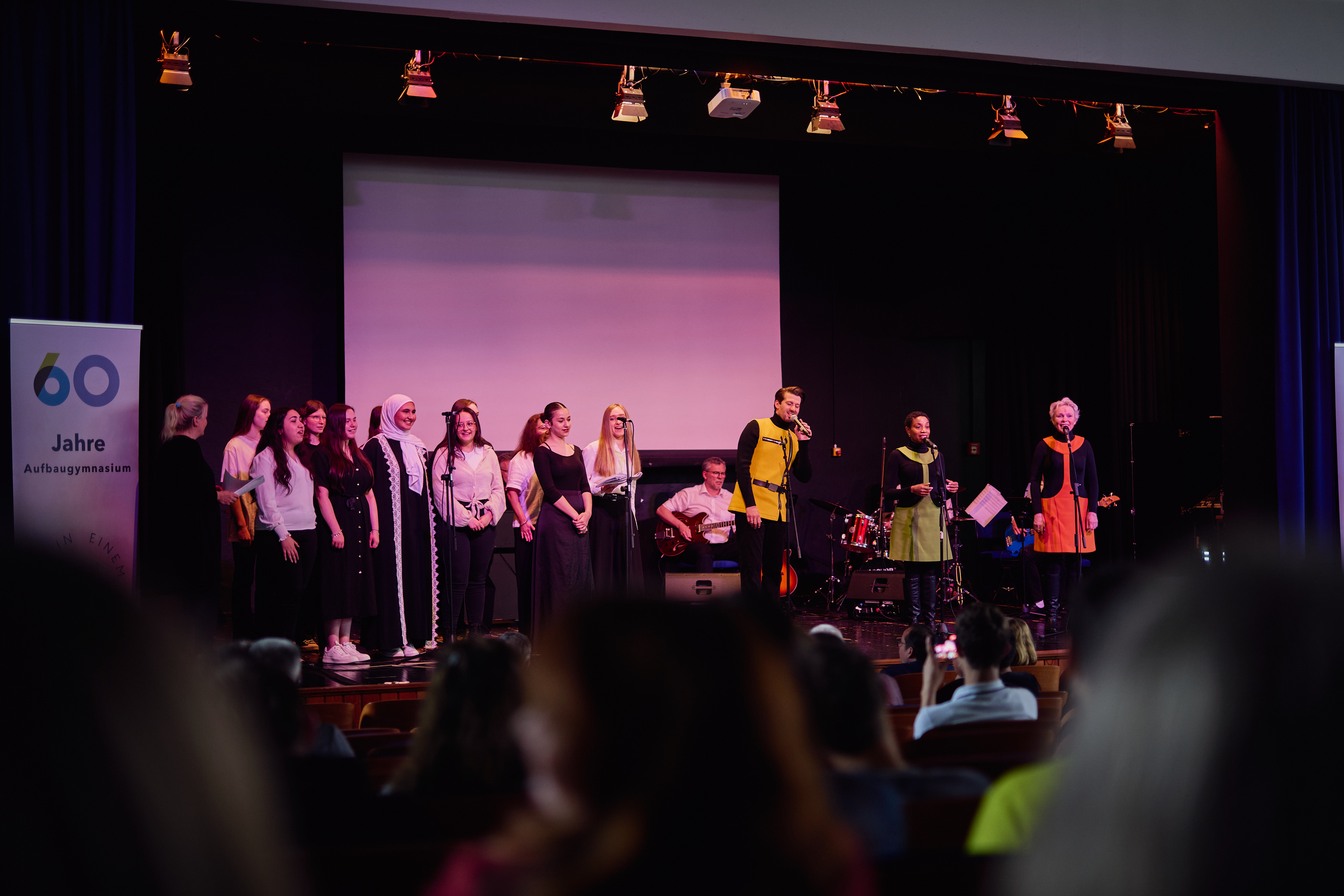 Schülerinnen und Schüler auf der Aula-Bühne beim 60-Jahre-Jubiläum